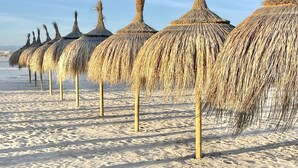 A row of thatched umbrellas on a sandy beach. - APARTBEACH FLUROMAR AIR-CONDITIONED RELAX NEXT TO THE BEACH (Salou)