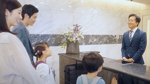 A reception area with a marble wall, a vase of flowers, and a reception desk. - Eslead Hotel  Namba Daikokucho (Osaka)