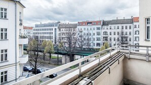 Un balcon donnant sur un paysage urbain, avec des bâtiments et un pont.