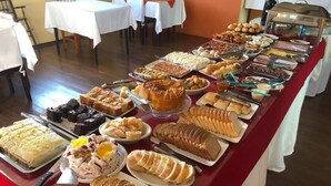 A buffet table with various food items and a cake. - Imperial Parque Hotel (Nova Petropolis)