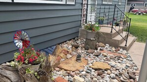 A house exterior with a welcome sign, a potted plant, and a decorative windmill. - Checkout this place!! Cindy and Rick will make your stay memorable! (Alma)