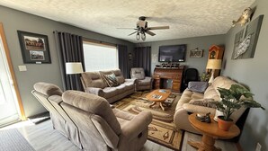 A living room with a sofa, two armchairs, a coffee table, a TV, and a ceiling fan. - Checkout this place!! Cindy and Rick will make your stay memorable! (Alma)