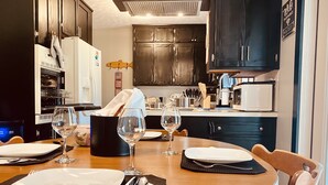 A dining area with a round table set for four, equipped with wine glasses and plates. - Checkout this place!! Cindy and Rick will make your stay memorable! (Alma)