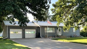 A two-story house with a garage, a welcome sign, and a mailbox. - Checkout this place!! Cindy and Rick will make your stay memorable! (Alma)