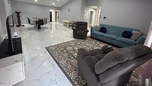 Un salón amplio con sofá, sillón y televisión.