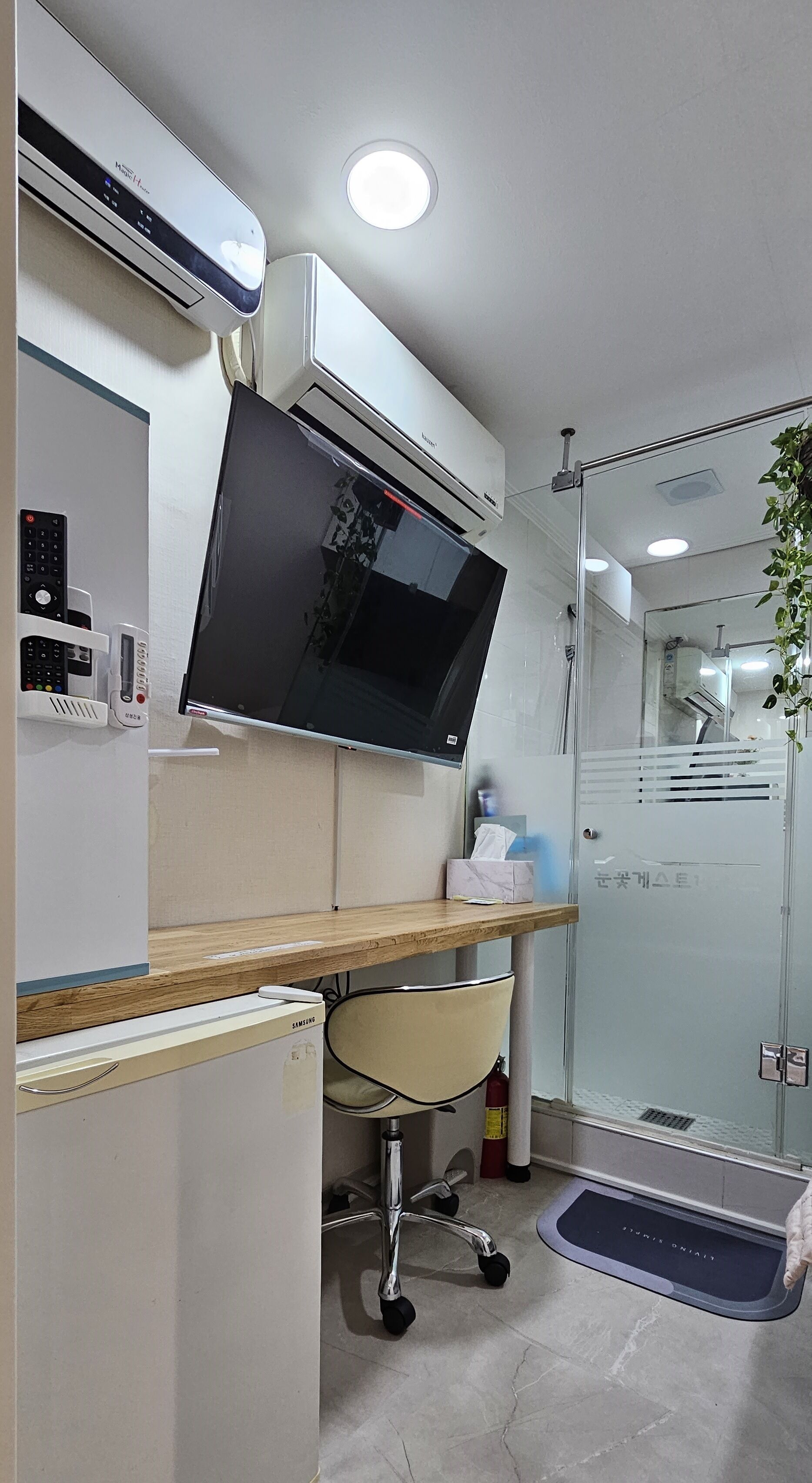 A modern bathroom with a built-in sink, a mirror, a toilet, and a shower area.