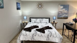 Una camera da letto con un letto, comodini, una scrivania e una sedia.