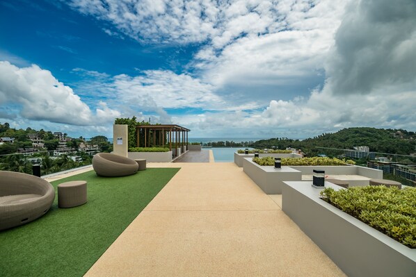 A rooftop terrace with a pool, green artificial grass, and modern seating. - Deluxe apartment at Panora by Lofty (Choeng Thale)