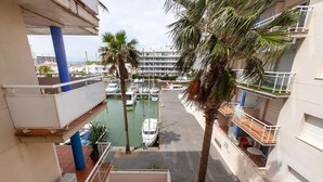 A marina with boats docked, surrounded by multi-story buildings with balconies. - Welcome to the charming apartment for rent in Roses, Costa Brava! 1500 meters from the beach, modern accommodation with canal views, sleeps 4. (Roses)