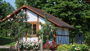Ein traditionelles Haus mit einem geneigten Dach, Holzbalken und einem Fenster.