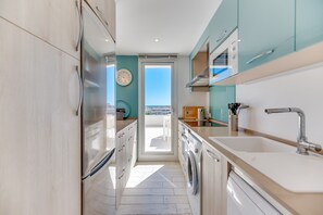 Une cuisine moderne avec vue sur la mer, un lave-linge et un évier.