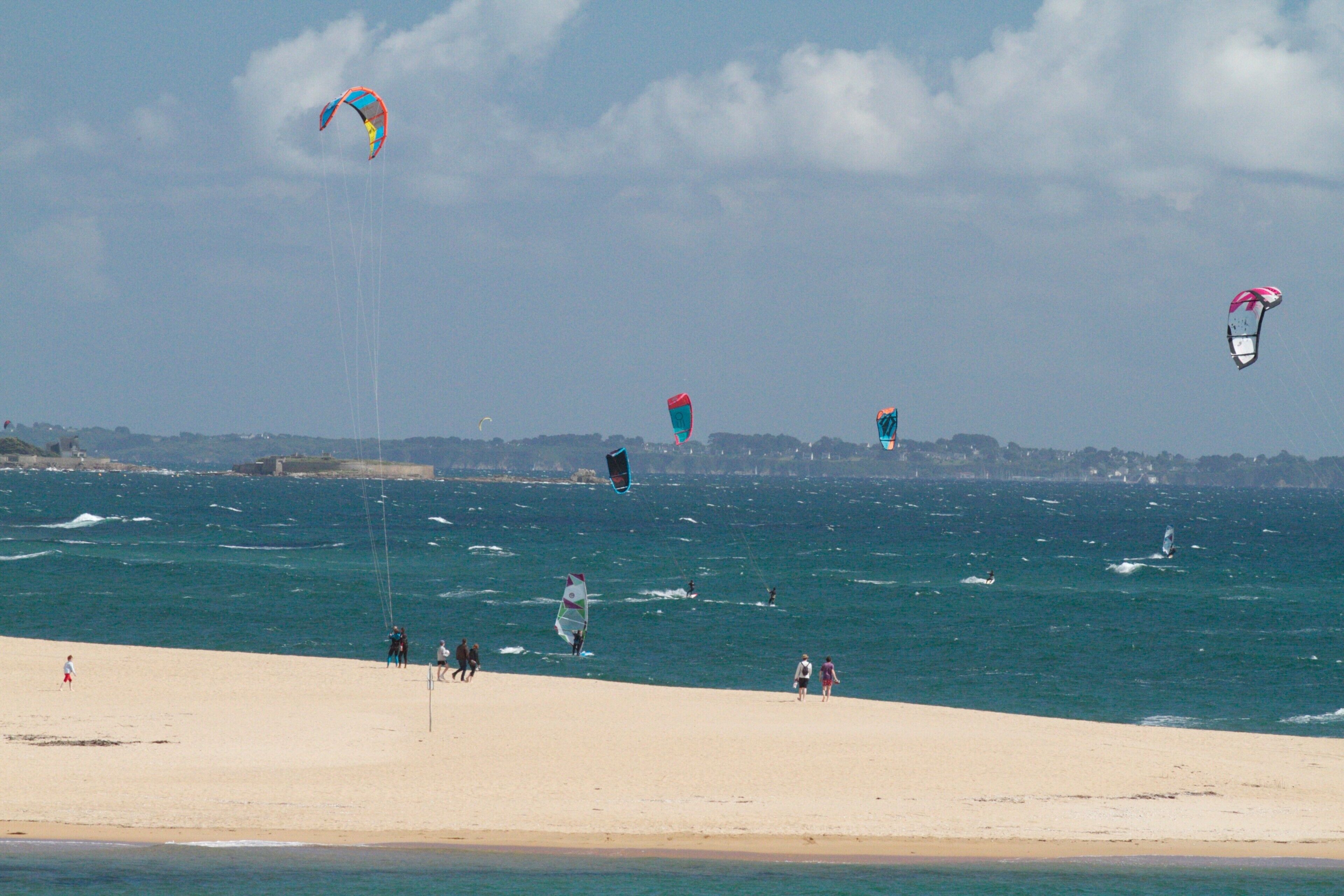 Ein Strand mit Menschen und Drachen.