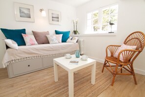 Une pièce comprenant un lit, une chaise, une table et une fenêtre.