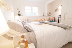 Ein Schlafzimmer mit Bett, Nachttisch, Lampe, Fenster und Dekoration.