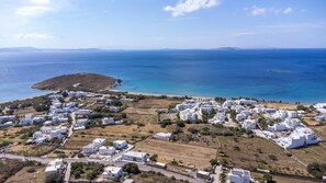 A coastal village with white buildings, a beach, and a clear view of the sea. - Holiday Home 'Anemologio 204 Tinos' with Sea View, Wi-Fi and Air Conditioning (Laouti)