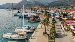 A marina with boats docked, a waterfront promenade, and buildings with shops. - Studio Apartment 'Mella Roa Teal' with Shared Terrace, Wi-Fi and Air Conditioning (Lefkada)