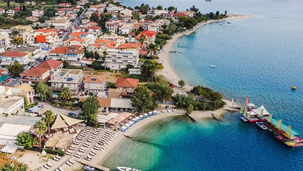 An aerial view of a coastal town with buildings, a beach, and boats. - Studio Apartment 'Mella Roa Teal' with Shared Terrace, Wi-Fi and Air Conditioning (Lefkada)
