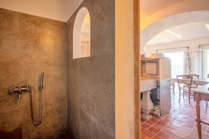 Un baño con ducha, lavamanos y ventana.