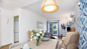 Un salon moderne comprenant une table à manger, un canapé et un fauteuil inclinable.
