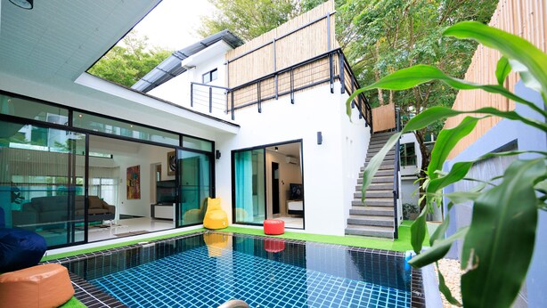 A modern house with a swimming pool, large glass windows, and a wooden deck. - Pool villa at Kamala Regent by Lofty (Kamala)