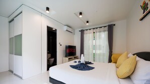 A modern hotel room with a large bed, a flat-screen TV, and a view of the outdoors. - Pool villa at Kamala Regent by Lofty (Kamala)