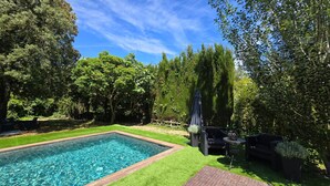 A rectangular swimming pool surrounded by well-maintained grass, with a wooden deck in the foreground. - Villa 'Del Sol' with Mountain View, Wi-Fi and Air Conditioning (Santa cristina D'aro)