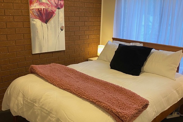 2 habitaciones, escritorio y tabla de planchar con plancha