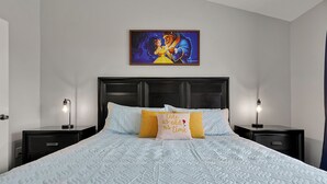 A neatly made bed with a quilted pattern, two bedside tables with lamps, and a framed picture above the bed. - Home minutes to Disney with private pool, arcade, waterslides, gated resort (Kissimmee)