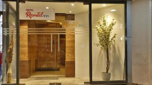 Entrada de un hotel con un letrero que dice "Hotel Ramotel inn".
