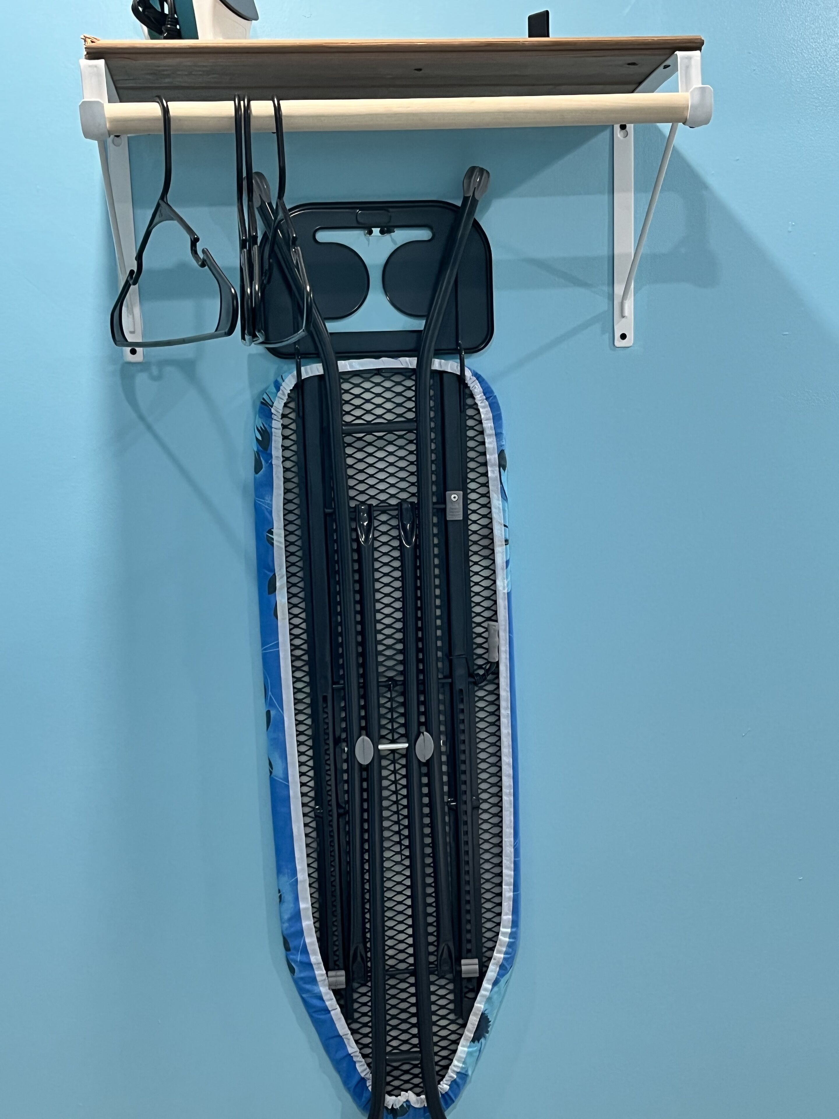 Ein an der Wand befestigtes Gestell mit einem Surfbrett und Paddeln.
