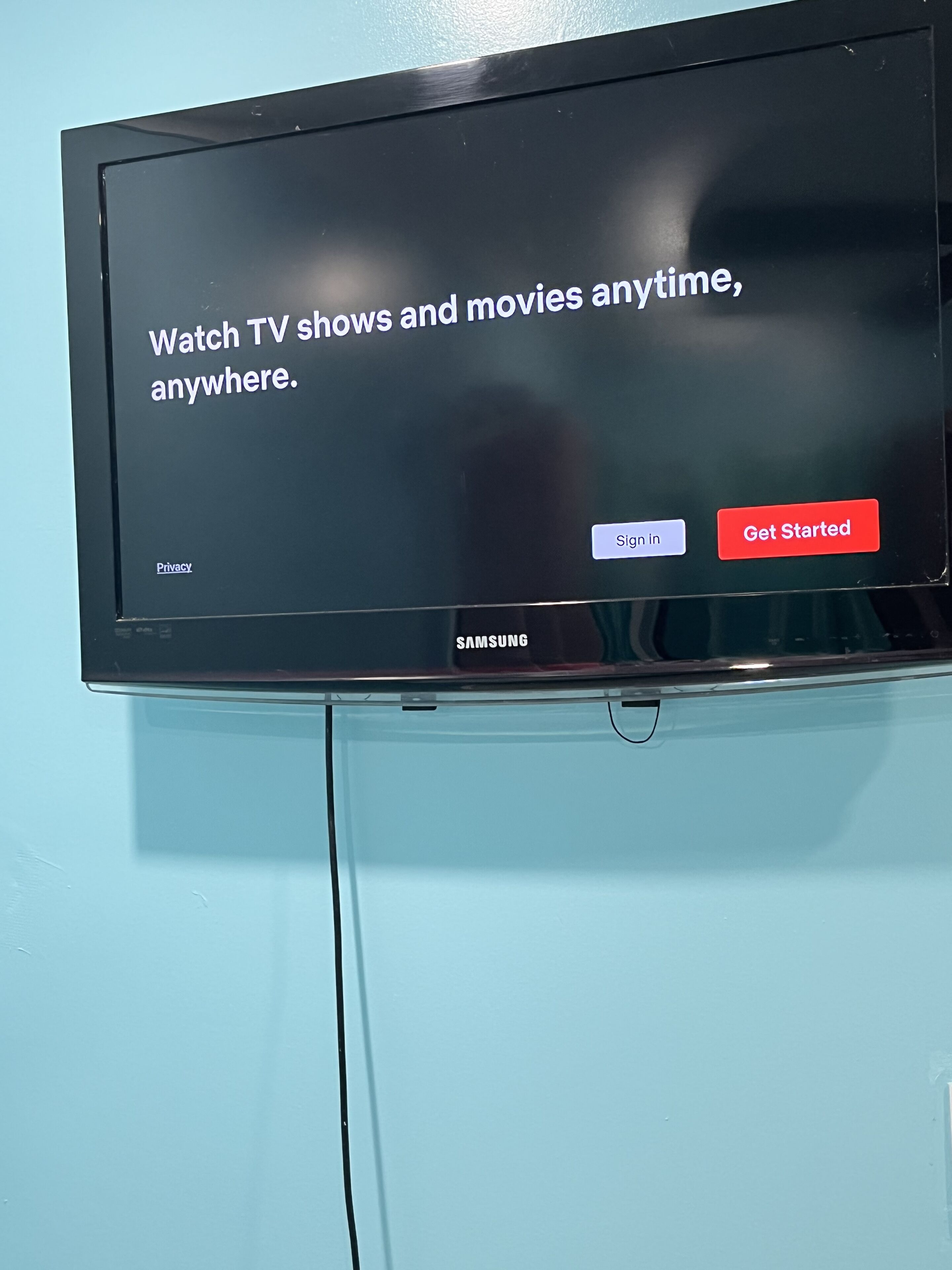 Een Samsung televisie bevestigd aan een muur, met een bericht over het bekijken van televisieseries en films wanneer je maar wilt.