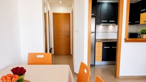 A dining area with a table, chairs, and a vase of flowers. - Apt  near center & port (Torrevieja)
