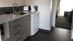 Et lille tekøkken med vask, brødrister og kaffemaskine.