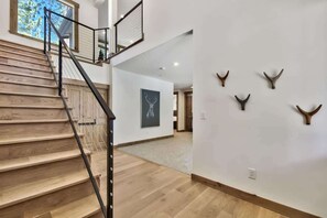 A staircase with wooden steps and metal railings, leading to a second floor. - Treetops Designer Lodge: Air Conditioning, Hot Tub (Tahoe Vista)