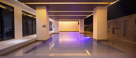 Un pasillo moderno de hotel con piso limpio y brillante, e iluminación cálida y acogedora.