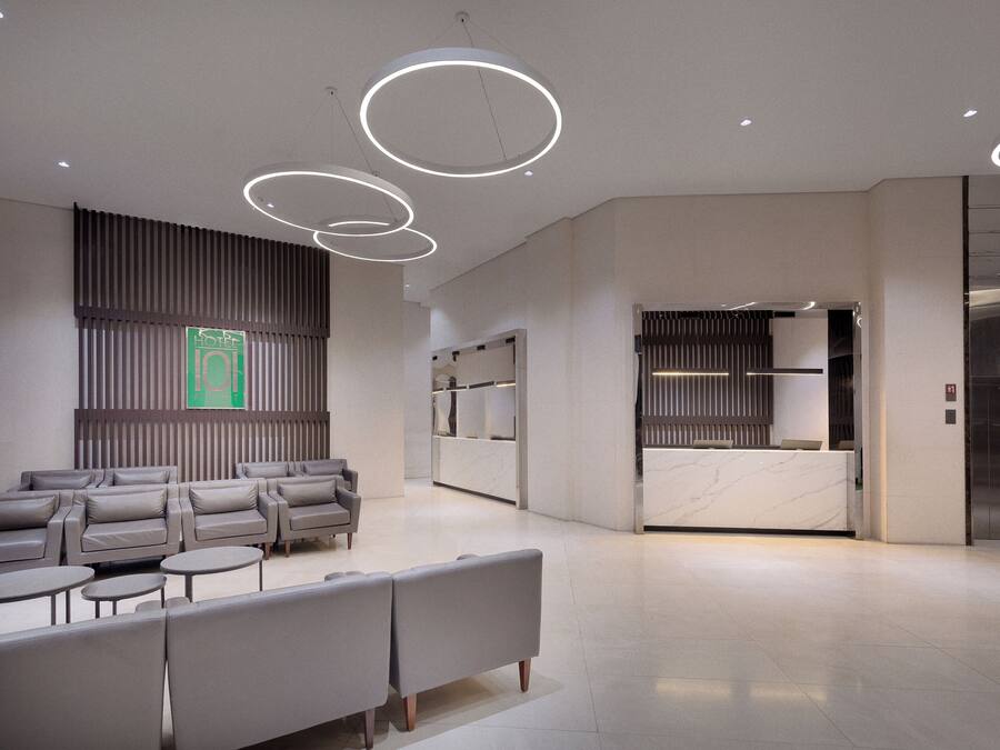 A modern hotel lobby with seating areas, a reception desk, and a reception area.