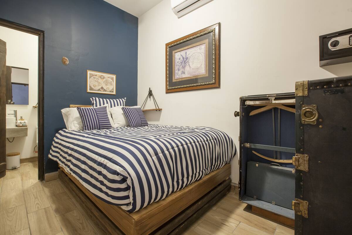 A bedroom with a bed, a dresser, and a wardrobe.
