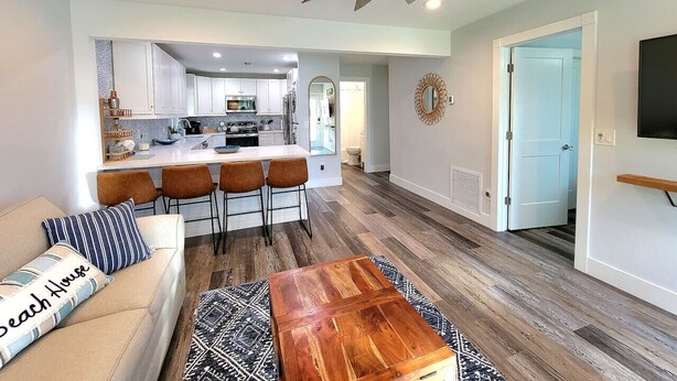 A modern living room with a sofa, coffee table, and a ceiling fan.