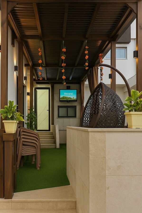 Enter a warm and inviting space with a welcoming sign, lush greenery, and a seating area.