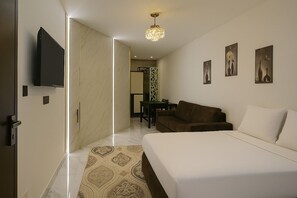Relax in a stylish space with a large bed, leather sofa, and flat-screen TV.