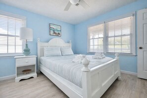A bedroom with a bed, nightstand, lamp, and windows with blinds. - Easy Like Sunday ★ Pet-Friendly ★ Walk to Beach ★ Sleeps 10 (Murrells Inlet)