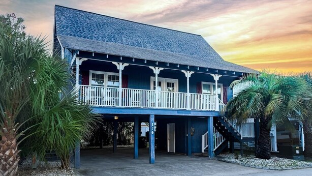 A two-story building with a balcony, a staircase, and a porch area. - Easy Like Sunday ★ Pet-Friendly ★ Walk to Beach ★ Sleeps 10 (Murrells Inlet)
