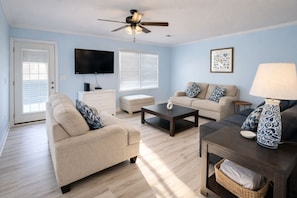 A living room with a sofa, coffee table, and a TV.