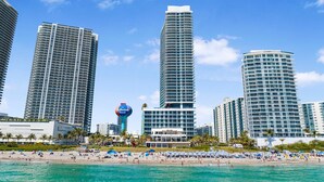 A beachfront hotel with high-rise buildings, a beach, and a clear blue sky. - Family 2BR | Beach Access | Sleeps 6 (Hollywood)