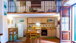 Une cuisine compacte avec un coin repas, des meubles en bois et un balcon avec vue.