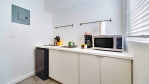 A compact kitchen with a dishwasher, a microwave, a coffee maker, and a small sink. - Modern Studio | Perfect Location | Total Comfort (Miami)