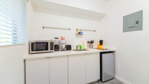 A compact kitchenette with a microwave, toaster, coffee maker, and a small sink. - Miami Studio | Minutes from Design District (Miami)