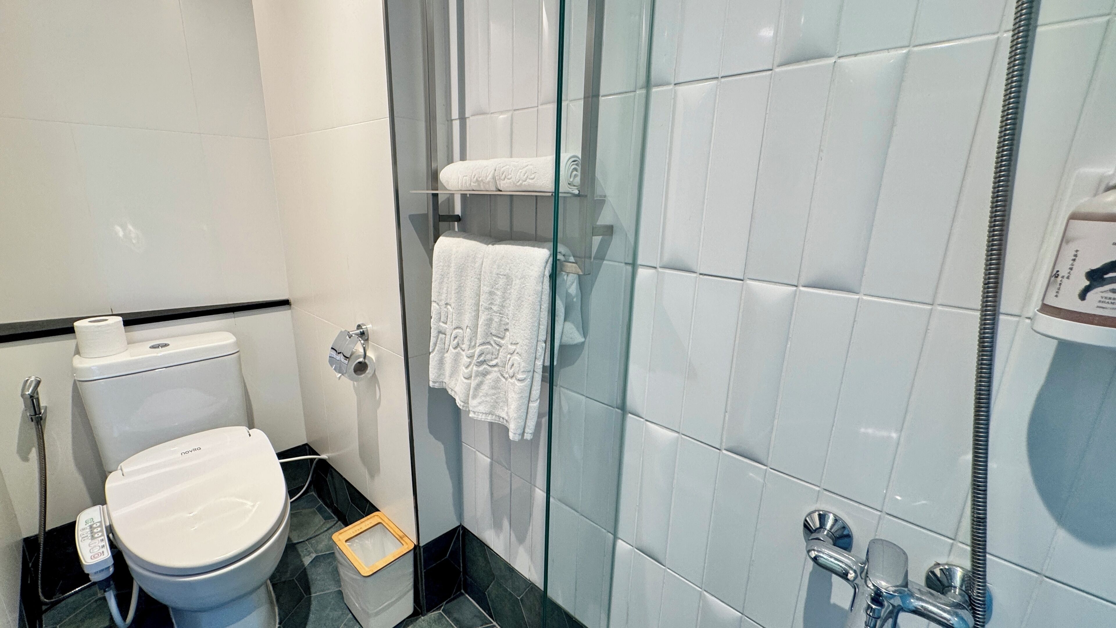Ein modernes Badezimmer mit Toilette, einer Duschkabine aus Glas und einem Waschbecken.