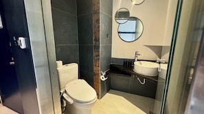 Un baño moderno con inodoro, bidé y dos lavamanos.