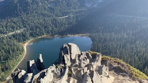 A mountainous landscape with a lake, rocky outcrops, and dense forests. - Private RV parking at the base of Mt. Rainier.  Have the forest to yourself! (Packwood)